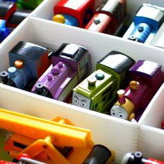 several toy cars are lined up in plastic containers