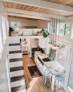 the interior of a tiny home with stairs leading up to the kitchen and dining area