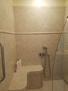 a walk in shower sitting next to a glass enclosed shower stall with hand held shower head