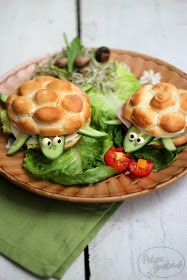 two small sandwiches are on a plate with lettuce