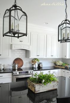 a kitchen filled with lots of white cabinets and black counter top space next to an oven