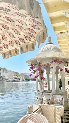 there is a gazebo with flowers on it next to the water