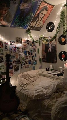 a bedroom with lots of posters and lights on the wall above the bed is covered in white sheets