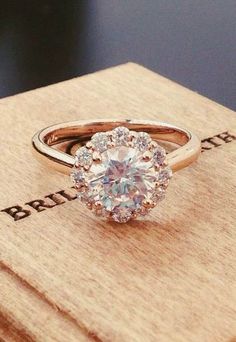 an engagement ring sitting on top of a wooden box