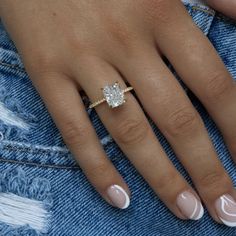 a woman's hand with a ring on her finger and a diamond in the middle