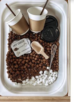 hot chocolate and marshmallows are arranged on a tray