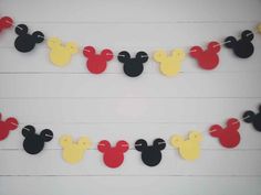 mickey mouse paper garland with red, yellow and black ears on white wood planks