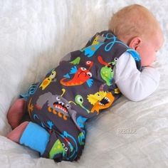 a baby laying on top of a white bed