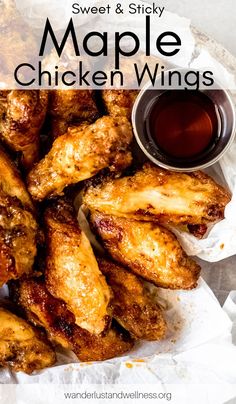 chicken wings and dipping sauce in a basket with paper on the side, ready to be eaten