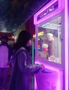 a person wearing a face mask standing in front of a vending machine