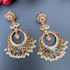 Featured are a pair of light and intricately crafted chandbalis in gold plated silver, studded with freshwater pearls and synthetic navratan lookalike stones. The earrings weigh 20gms Wath Video Here Luxury White Meenakari Chandbalis, Elegant Designer Chandbali Jhumkas, Elegant Designer Chandbalis With Meenakari, Elegant Designer Meenakari Chandbalis, Elegant Meenakari Chandbalis For Designer Wear, Festive Designer Earrings With Cutdana, Designer Chandbali Earrings For Diwali, Designer Chandbali Earrings For Festive Occasions, Festive Cutdana Earrings For Designer Wear