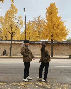 two people standing in the street holding hands