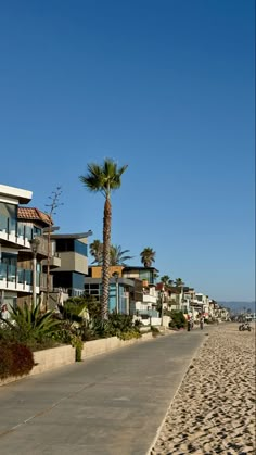 the beach is lined with palm trees and apartment buildings on either side of the road