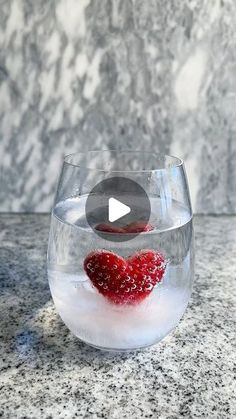 a glass bowl filled with water and some raspberries