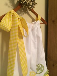 Lemonade Summer Party Dress with a lovely gingham yellow fabric bow on adjustable neckline, appliquéd lemons , limes and oranges on front and back. Green and yellow country ruffle just above hem. So cute for a lemonade theme birthday party or even your local summer lemonade stand This dress is a One of a kind and very versatile. Length of dress from gathered neckline to hem is 21 1/2 inches long. Armhole area is 5 inches long and of course the gingham yellow bow sets on shoulder. Full width at h Cute Tie Back Dress For Picnic, Summer Picnic Dress With Bow Detail, Summer Picnic Dress With Bow, Spring Picnic Dress With Bow, Cotton Dress With Bow Tie Back For Garden Party, Cotton Lemon Print Dress For Garden Party, Cute Cotton Dress With Bow Tie Back, Cute Yellow Dress For Picnic, Cotton Gingham Dress For Brunch