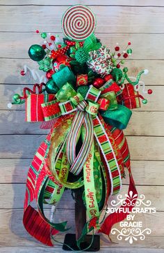 a christmas wreath with candy canes and candies on the top is hanging on a wooden wall