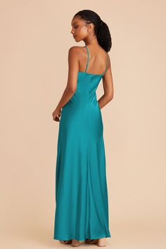 a woman in a teal dress looking back