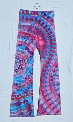 a tie - dyed pair of pants with a clock on the wall in the background