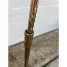 a tall metal pole sitting in front of a white garage door on concrete flooring