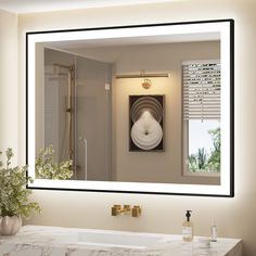 a bathroom with a large mirror above the sink and a vase on the counter next to it