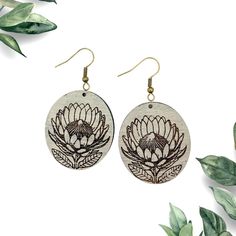 the earrings are made from wood and have an image of a large flower on it