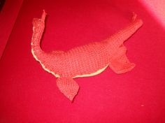 a red stuffed animal laying on top of a red surface