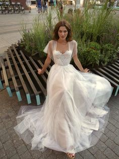 a woman in a white dress sitting on a bench