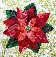 a red and green poinsettia is on a white tablecloth with floral designs