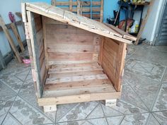 a small wooden structure sitting on top of a tile floor next to a blue wall