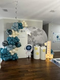 a room decorated with balloons, stars and an moon on the wall in front of it