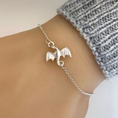 "Pictures are enlarged to show details of the item. Please refer to original size and measurements in the following description  A delicate sterling silver bracelet with a detailed sterling silver flying dragon link (15mm) connected to sterling silver chain.   Made of 925 sterling silver. - Adjustable bracelet length from 6.5\" to 7.5\", adjustable anklet length (approx. 8.5\" to 9.5\"). Prefer different length? Please leave a note during checkout. Simple and it looks good with anything! ENTER OUR SHOP HERE for more jewellery : https://etsy.me/2yqbxk6 STORE POLICY: To make sure you're always 100% satisfied please read our store policies here prior to ordering: https://etsy.me/2RoEchD FOLLOW US on Facebook, Pinterest and Instagram: https://www.facebook.com/JewelleryByZM https://www.pinteres Gold Bracelet For Women Dragon, Tattoo Dragon Bracelet, Dragon Jewelry Silver, Amazon Dragon Bracelet, Dragon Jewellery, Silver Bracelet Designs, Dragon Bracelet, Jewelry Bracelets Silver, Magical Jewelry