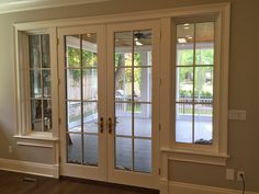 an empty living room with french doors and windows