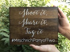 someone holding up a wooden sign that says shoot it share it tag it misch party two