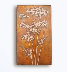 a metal wall hanging with flowers on it's side, mounted to the wall