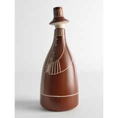 a brown vase sitting on top of a white table