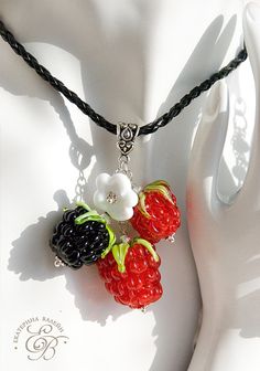 a close up of a necklace on a mannequin's head with fruit