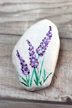 a rock with lavender flowers painted on it