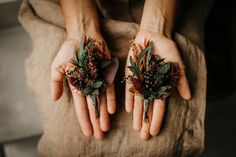 two hands holding flowers and greenery in their palms