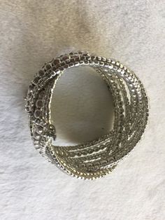 "Elegant beaded silver bracelet from the 40s with a distinctive wrap around design with silver beads of varying sizes interwoven in a pattern. In the back are four little charms that move as you move your wrist. Measures about 1.5\" in wide and very flexible, adjustable cuff style. Very understated yet fancy; would be a good wedding bracelet! Also, please take a look at my storefront at: https://www.etsy.com/shop/FabFinds42?ref=seller-platform-mcnav I have a wide selection of one-of-a-kind items Silver Beaded Bracelets With Strap For Party, Silver Beaded Crystal Bangle Bracelet, Stackable Bangle Bracelets For Party, Crystal Bangle Bracelet With Silver Beads, Adjustable Silver Wrap Bracelet Bangle, Silver Stackable Stretch Bracelet For Parties, Adjustable Silver Bangle With Beads, Stackable Metal Cuff Bracelet For Party, Silver Adjustable Flexible Bangle