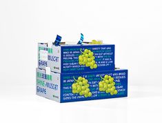 three boxes with grapes on them are stacked next to each other in front of a white background