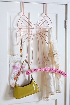 there are two purses hanging on the wall next to a handbag and necklace holder