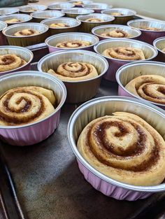 several pans filled with cinnamon rolls on top of a table