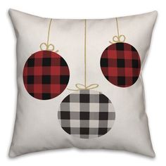 a white pillow with red and black plaid ornaments hanging from it's sides on a string