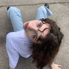 a woman laying on the ground with her eyes open