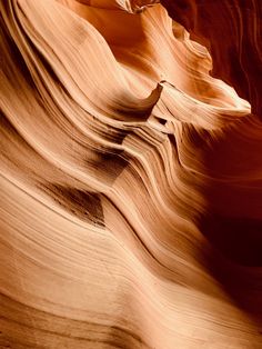 an image of the side of a canyon with waves in it's rock formations