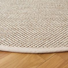 a close up view of a rug on the floor with wood floors in the background