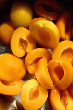 peeled apricots are sitting in a metal bowl