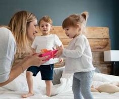 a woman and two small children on a bed