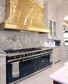 a kitchen with an oven, range and counter tops in gold foil on the hood