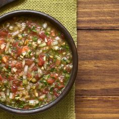 a bowl filled with soup sitting on top of a table next to a wooden spoon